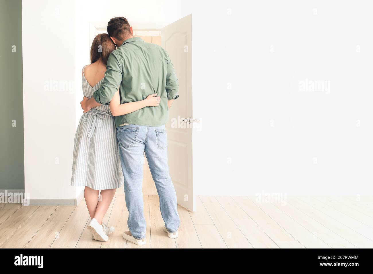 Happy couple in front of door at their new home Stock Photo - Alamy