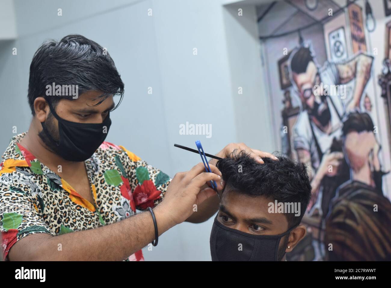 Hyderabad, Telangana, India. june292020 A hairdresser, wearing a protective face mask, works