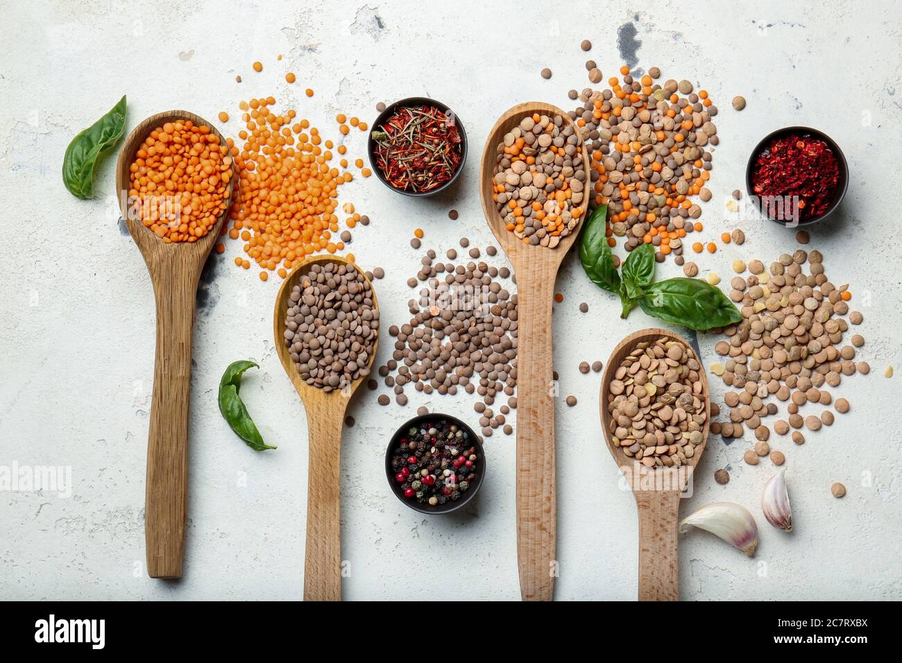 Spoons with lentils and spices on white background Stock Photo