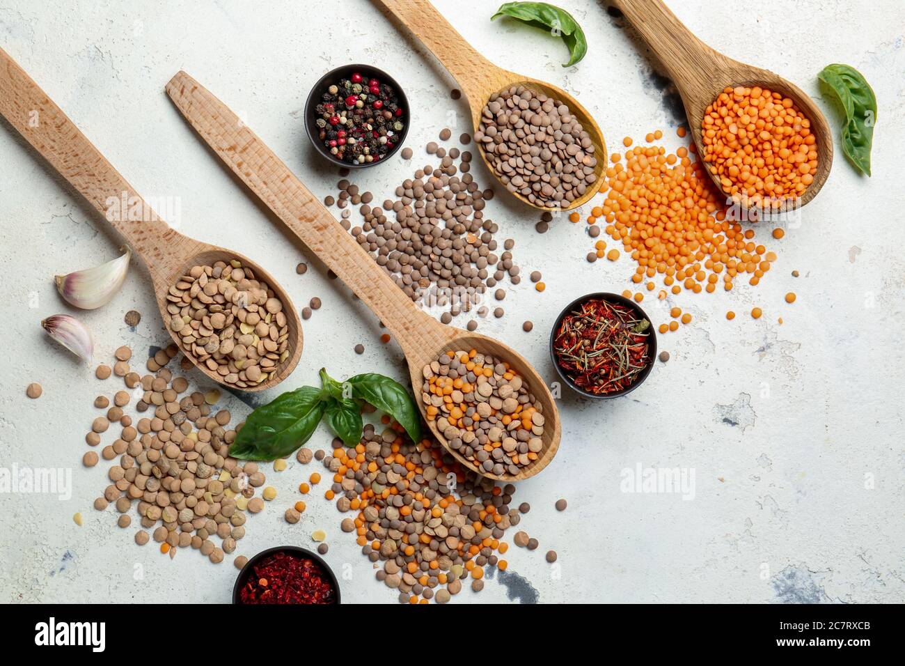 Spoons with lentils and spices on white background Stock Photo