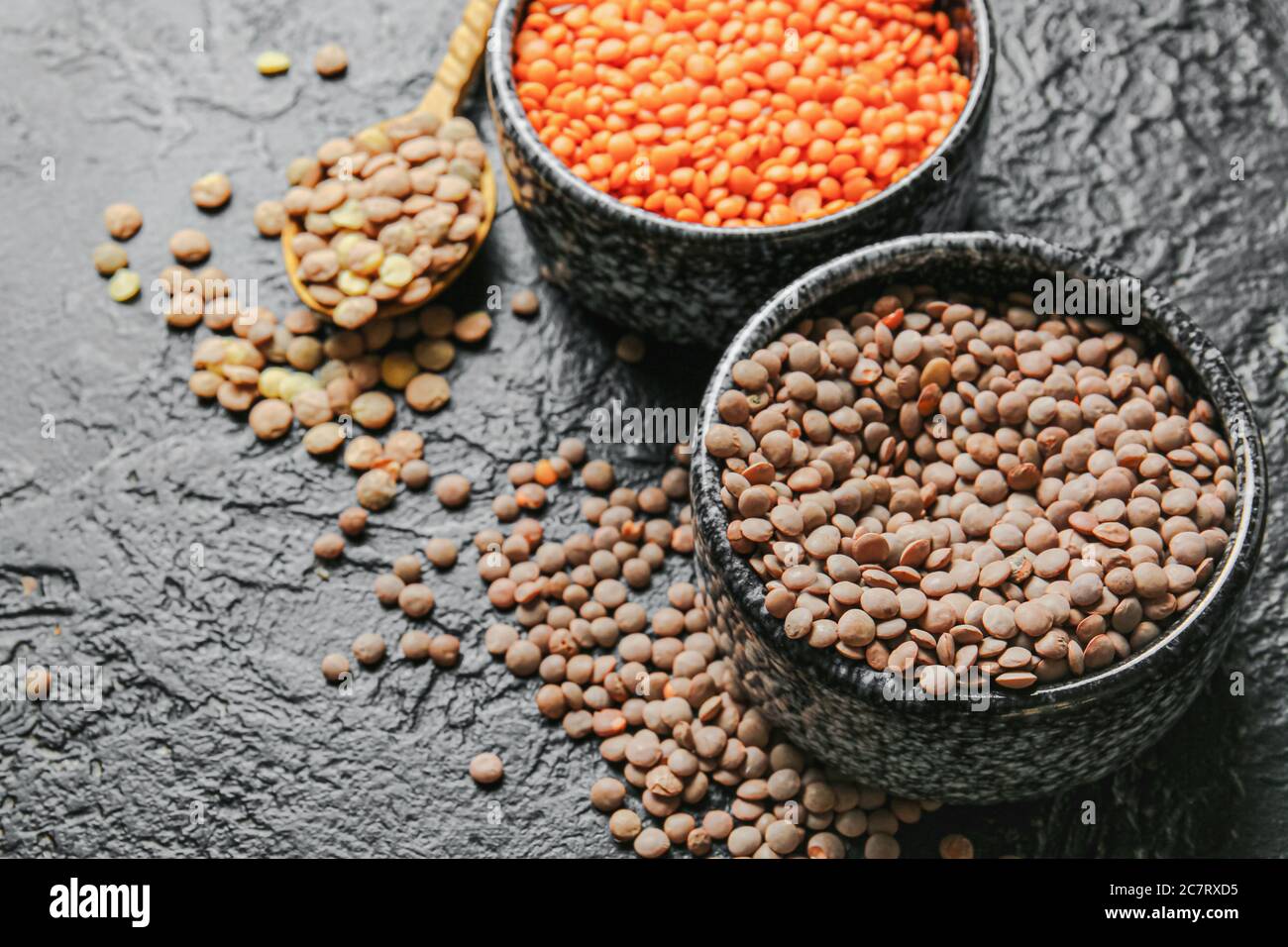 Bowls with lentils on dark background Stock Photo