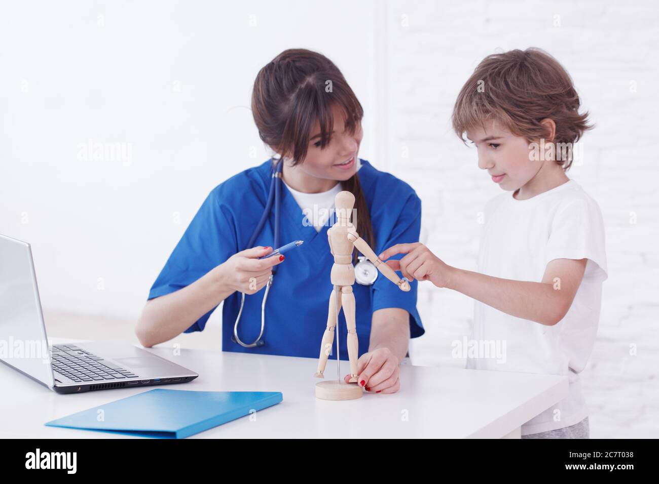 Doctor showing anatomical doll to her child patient in medical office Stock Photo