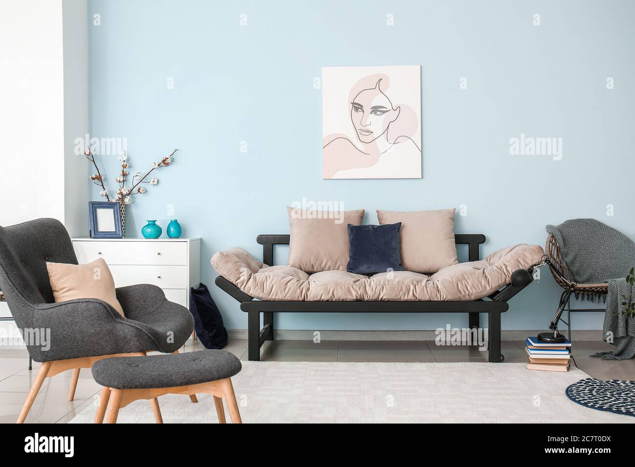 Interior of modern room with sofa, armchair and ottoman Stock Photo - Alamy
