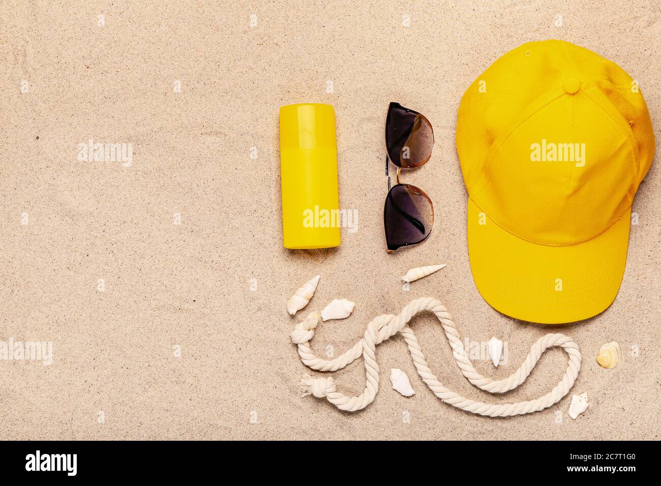 Stylish beach accessories on sand background Stock Photo