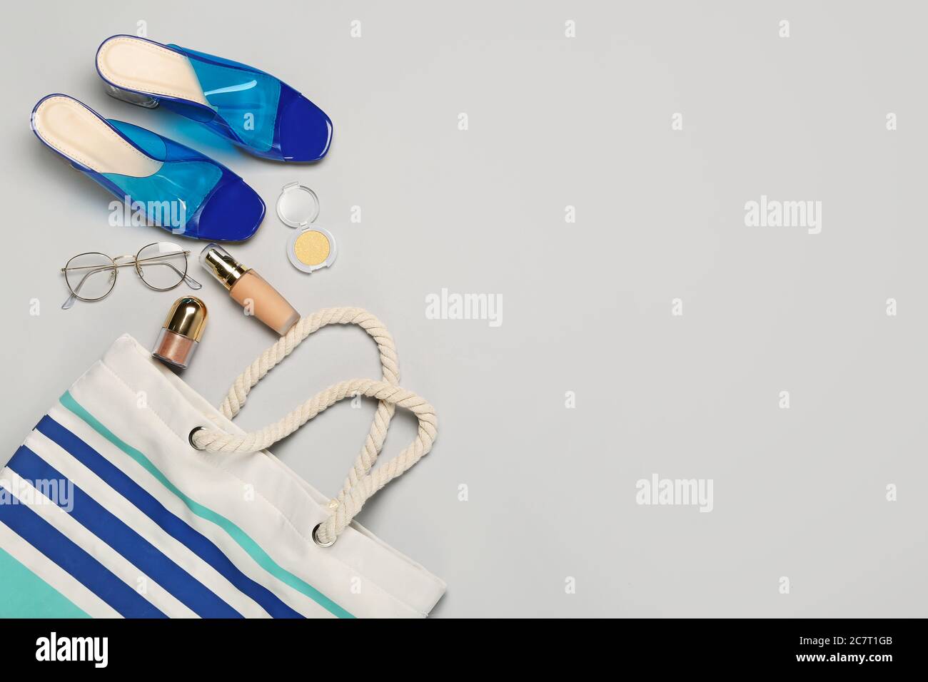 Makeup cosmetics with beach accessories on light background Stock Photo