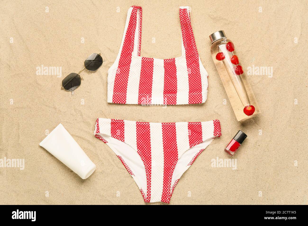 Stylish beach accessories on sand background Stock Photo