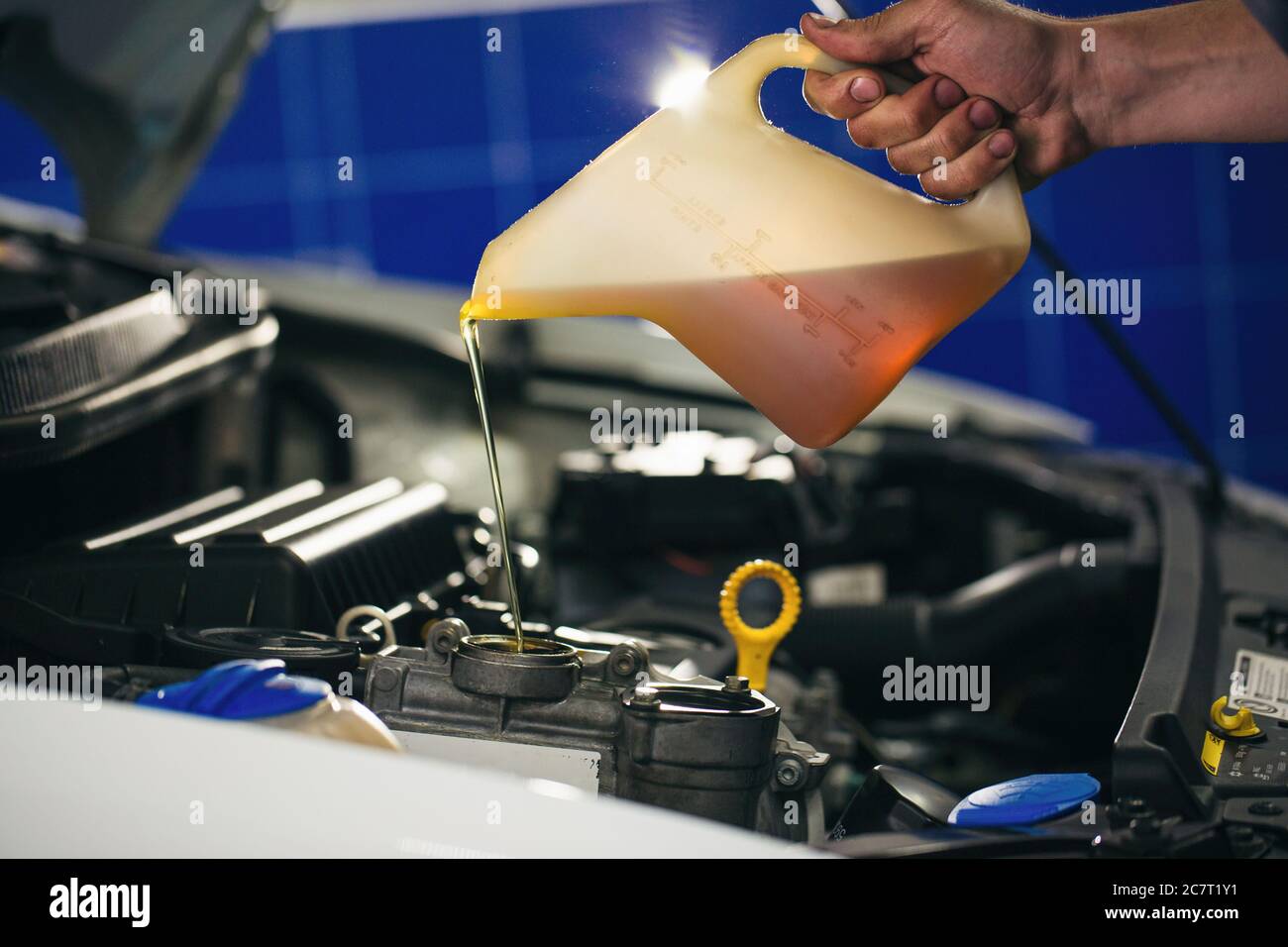 Auto mechanic is changing motor oil into a engine at car station Stock ...