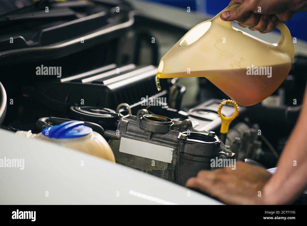 Auto mechanic is changing motor oil into a engine at car station Stock ...