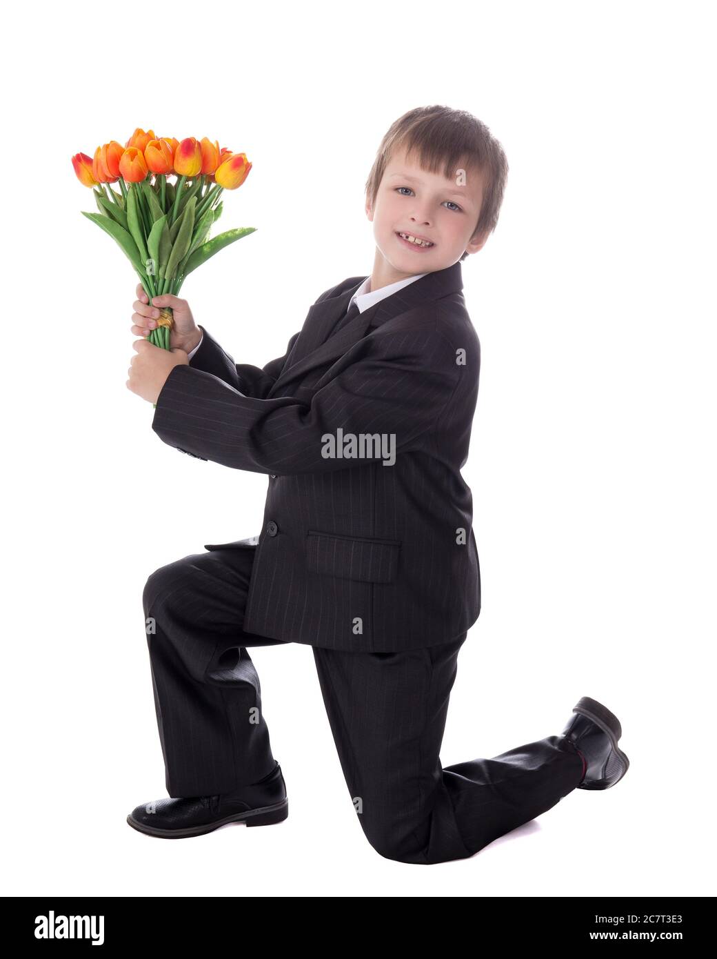 side view of little boy in business suit giving flowers to somebody