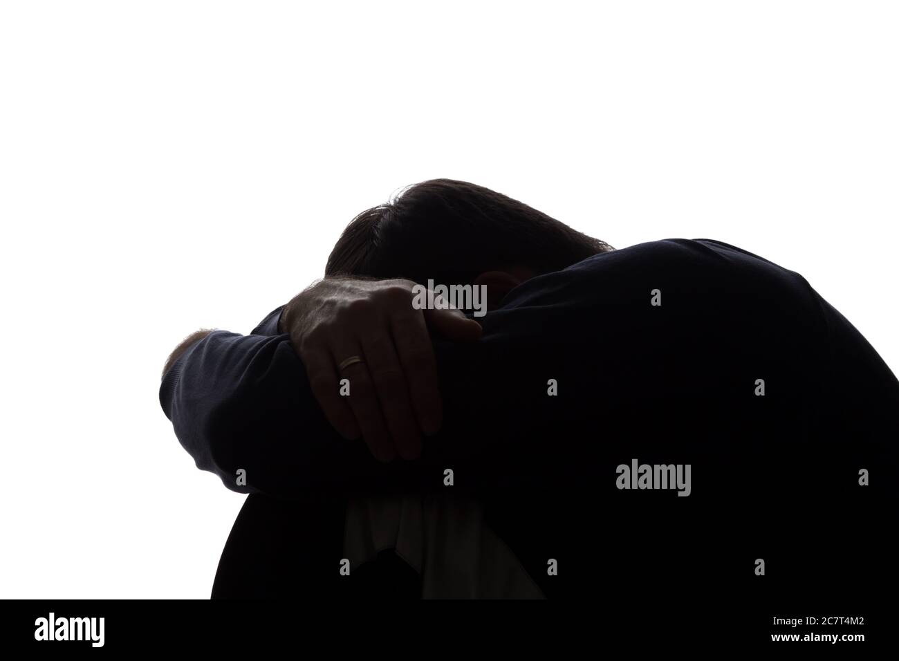 A young man with grief tearing at her hair - silhouette Stock Photo