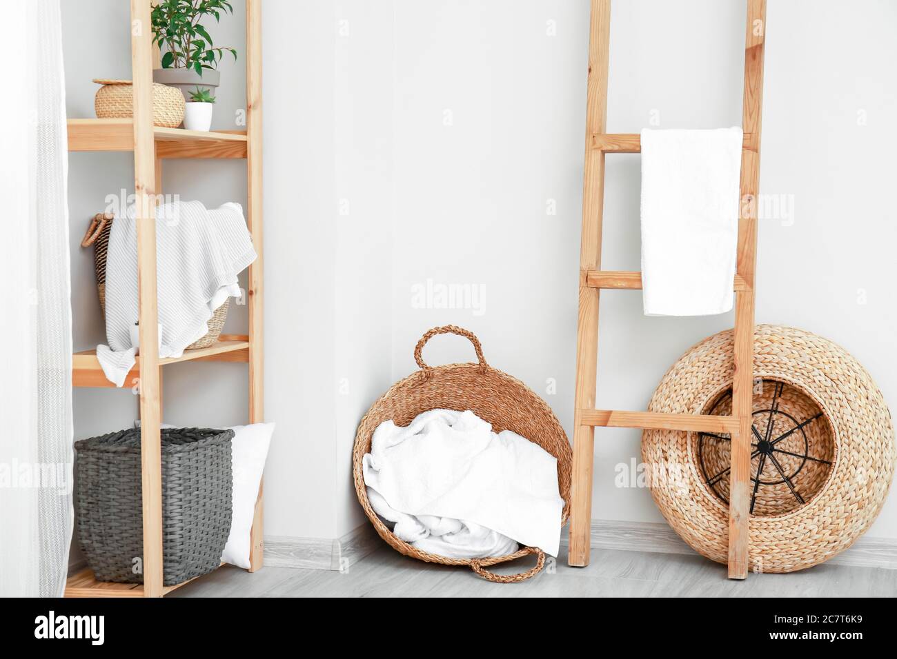 Rack and wicker baskets with towels in room Stock Photo Alamy