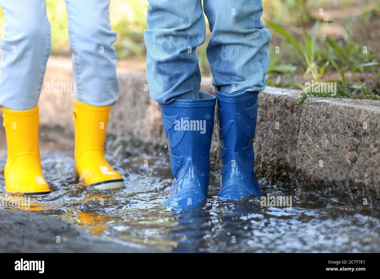 Cute little children wearing gumboots outdoors on rainy day Stock Photo ...