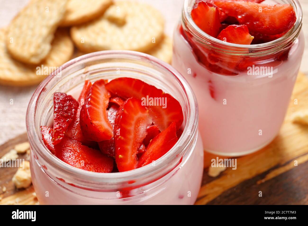 Jars of healthy strawberry yogurt on table, closeup Stock Photo