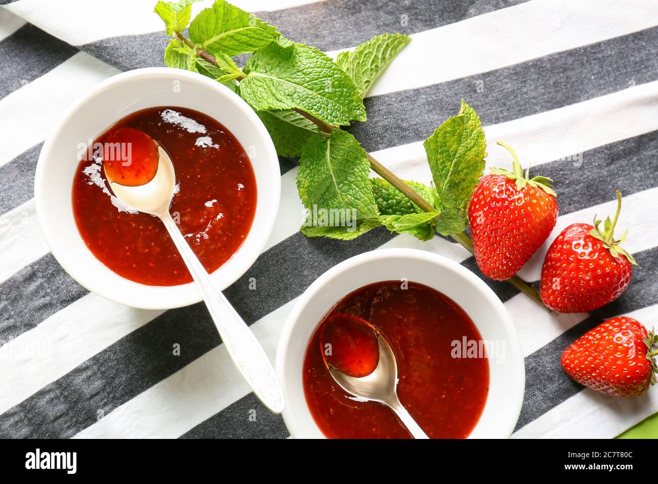 Bowls of tasty strawberry jam on table Stock Photo