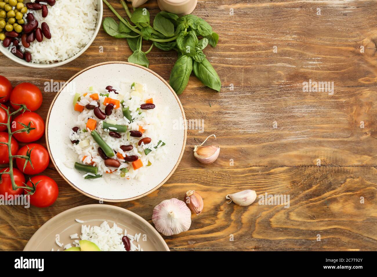 Plates with tasty rice, beans, vegetables on table Stock Photo
