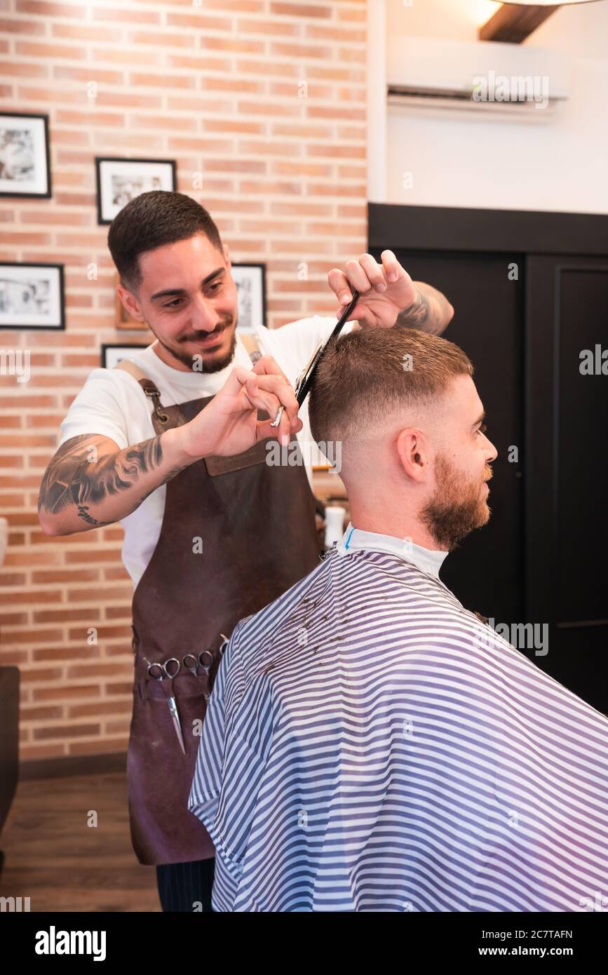Vertical shot of a hairdresser cutting the male customer's hair with a hair clipper and a comb Stock Photo - Alamy Vertical shot of a hairdresser cutting the male customer's hair with a hair clipper and a comb Stock Photo - Alamy