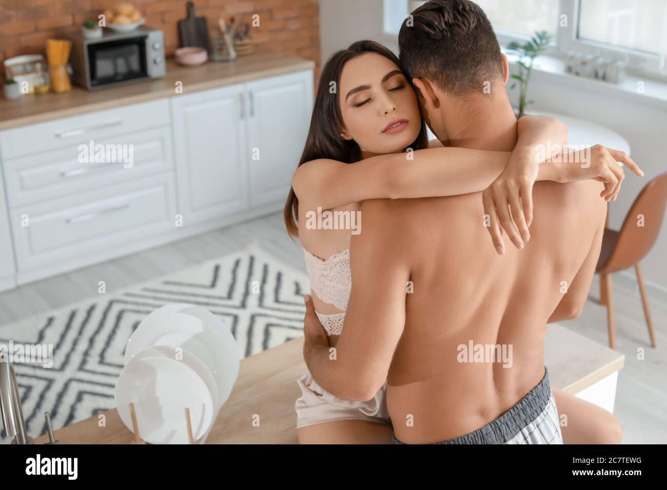Passionate young couple in kitchen at home Stock Photo