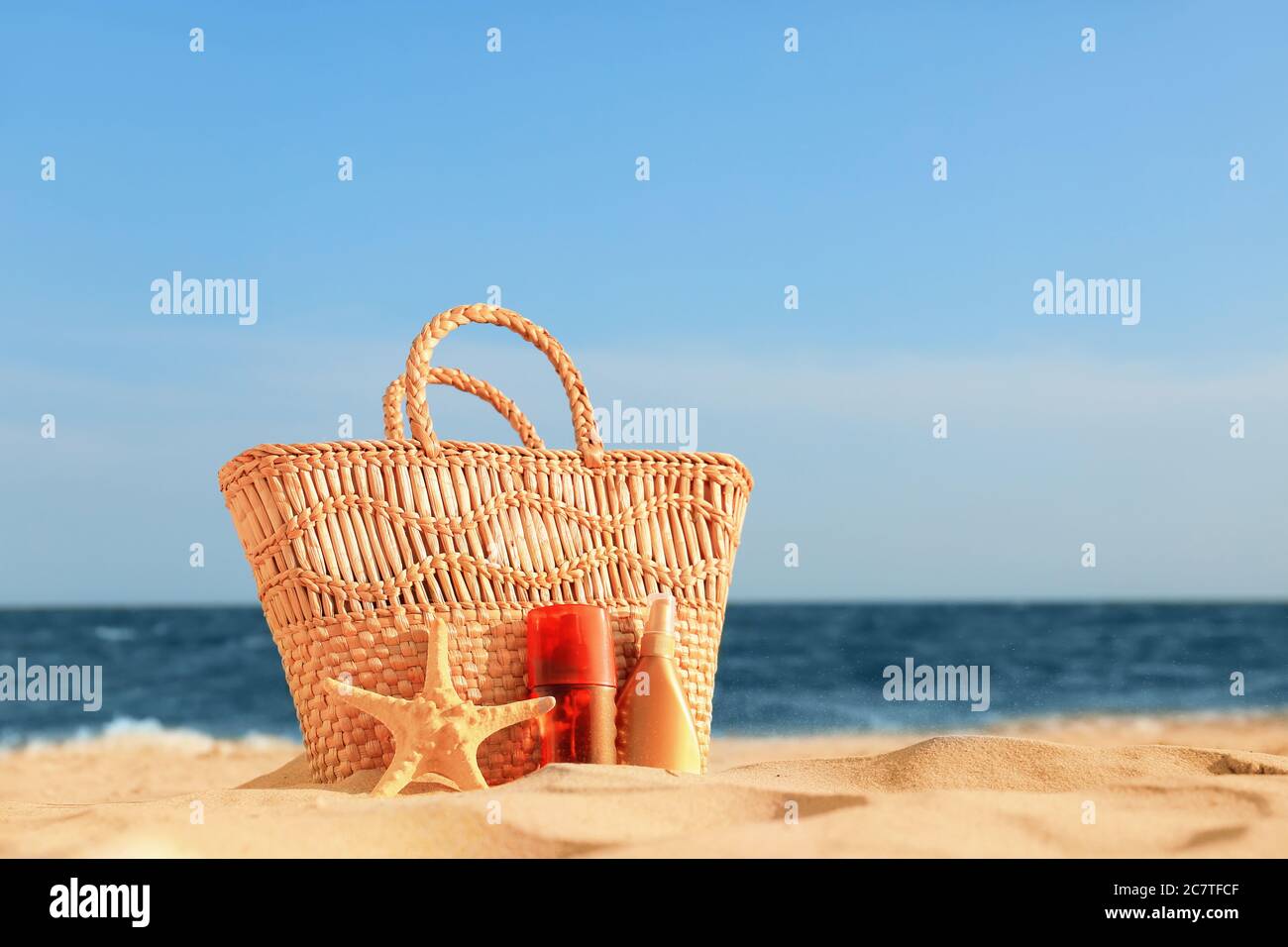 Bag with sunscreen cream on beach Stock Photo