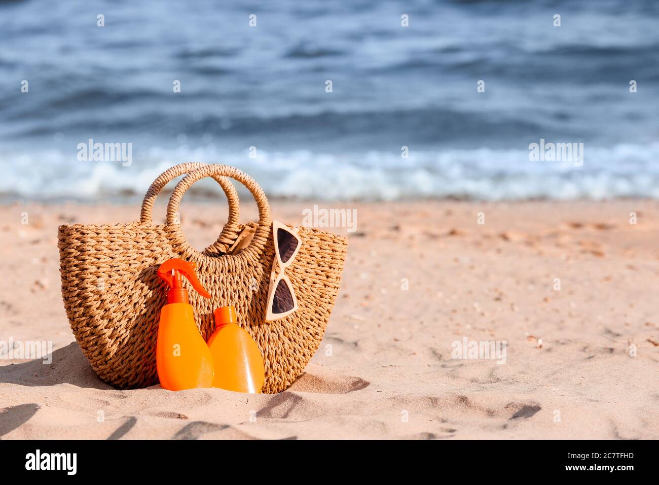 Bag with sunscreen cream on beach Stock Photo