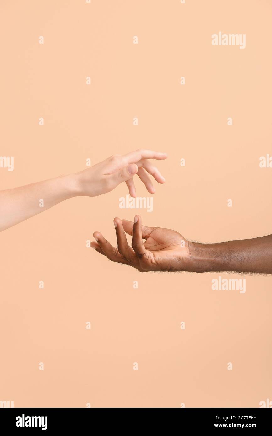 Hands of Caucasian woman and African-American man on color background. Racism concept Stock Photo