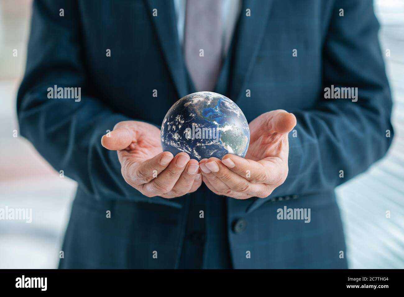 Businessman is holding world sphere. concept of beeing connected and ruling the world, global domination. Elements of this Image Furnished by NASA Stock Photo
