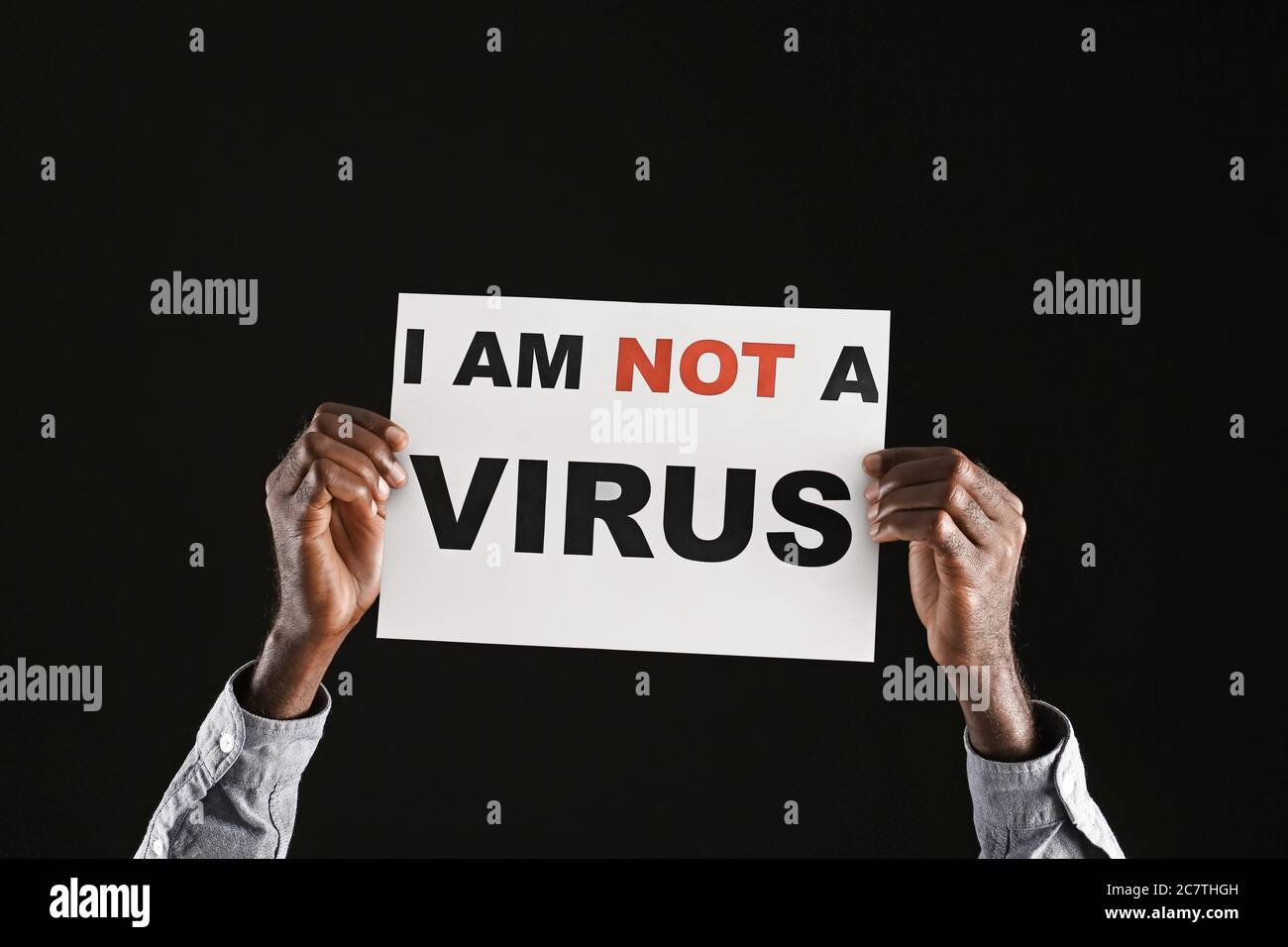 African-American man with poster on dark background. Stop racism Stock Photo