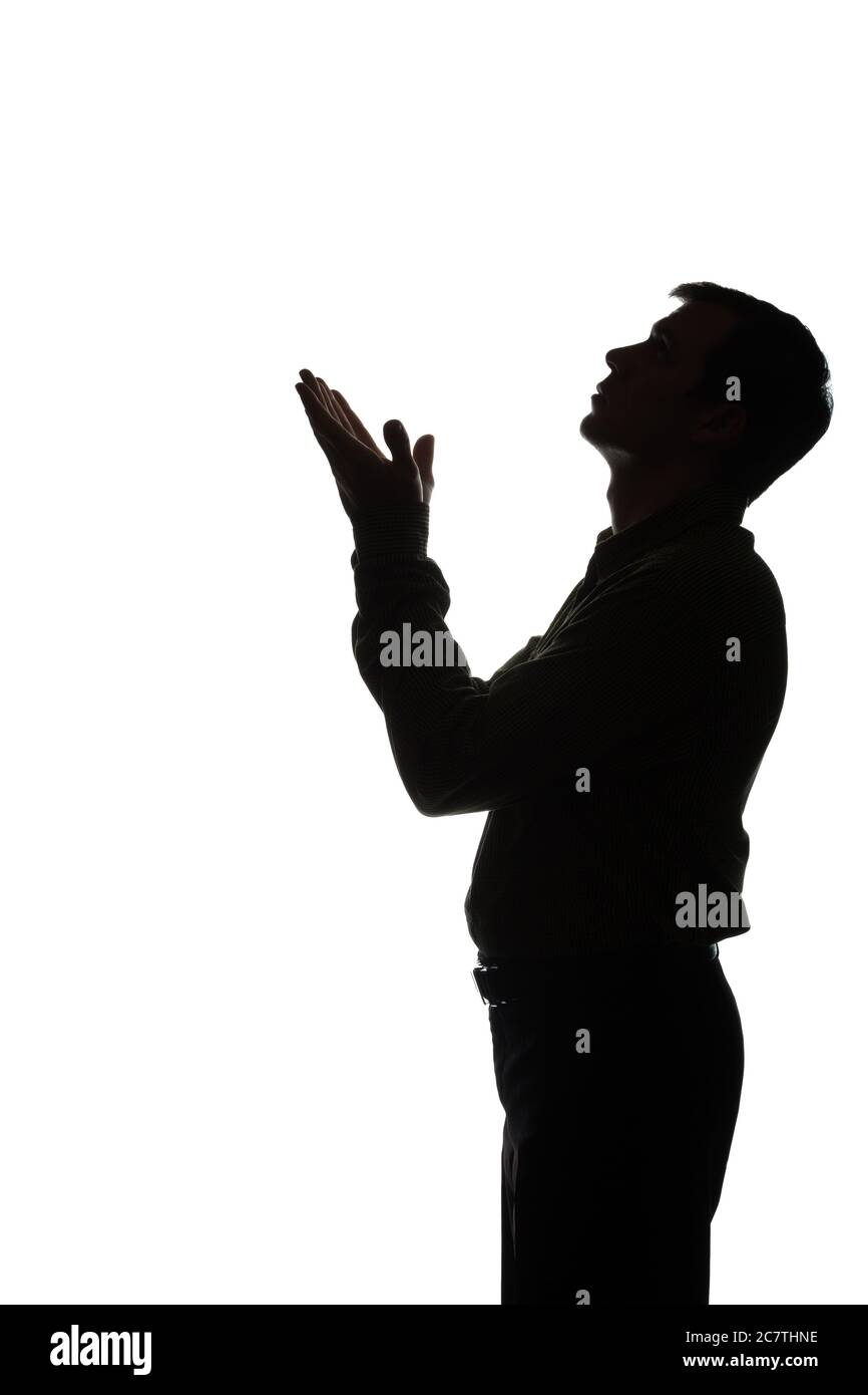 Young man looking up with hope and request - silhouette of a side view Stock Photo