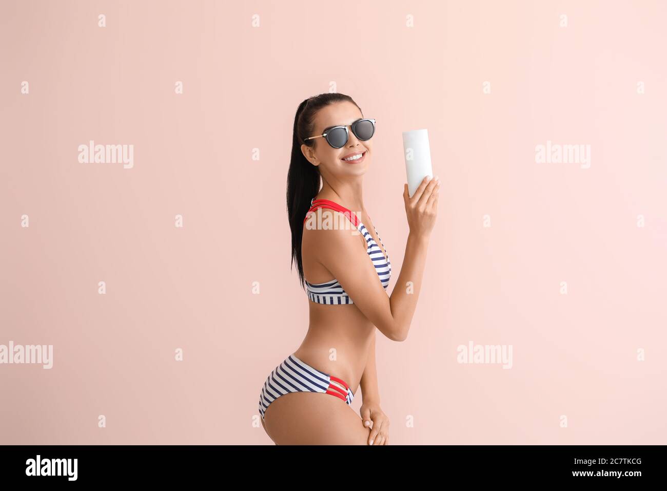 Happy young woman with sun protection cream on color background Stock Photo