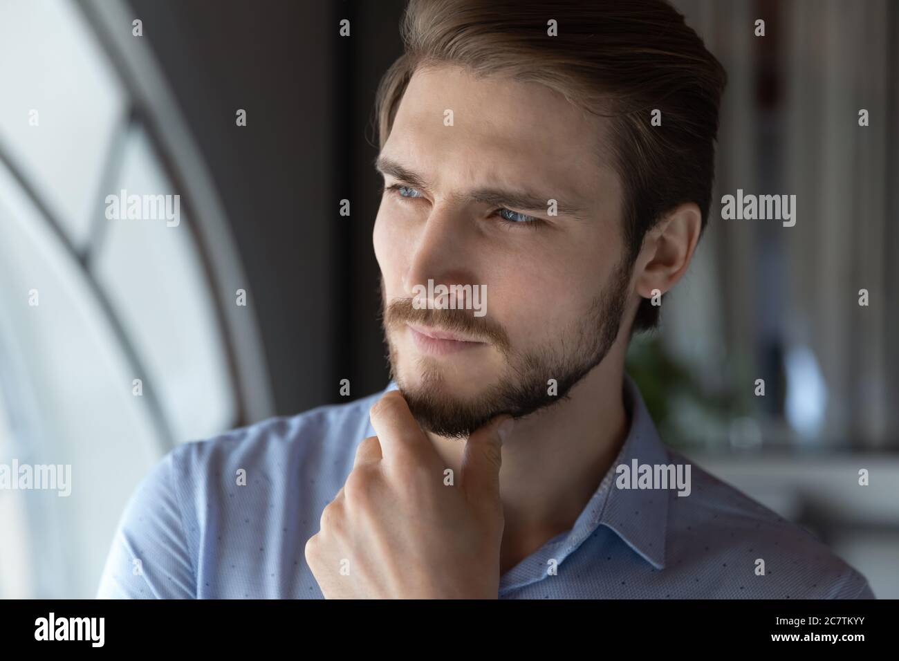 Pensive young caucasian man look in distance thinking Stock Photo