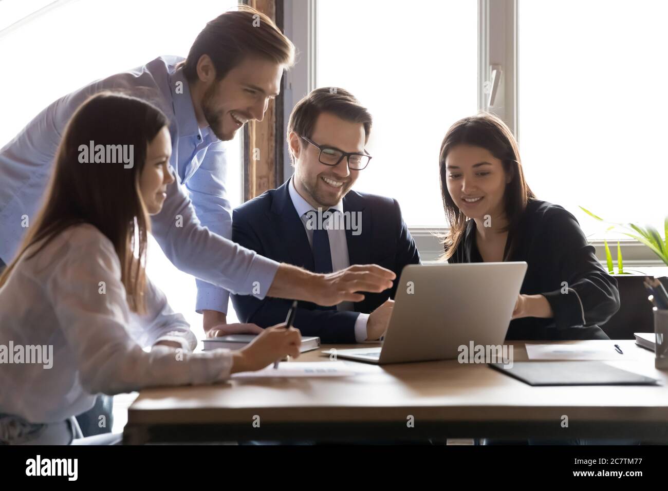Smiling multiracial colleagues have fun working on laptop Stock Photo
