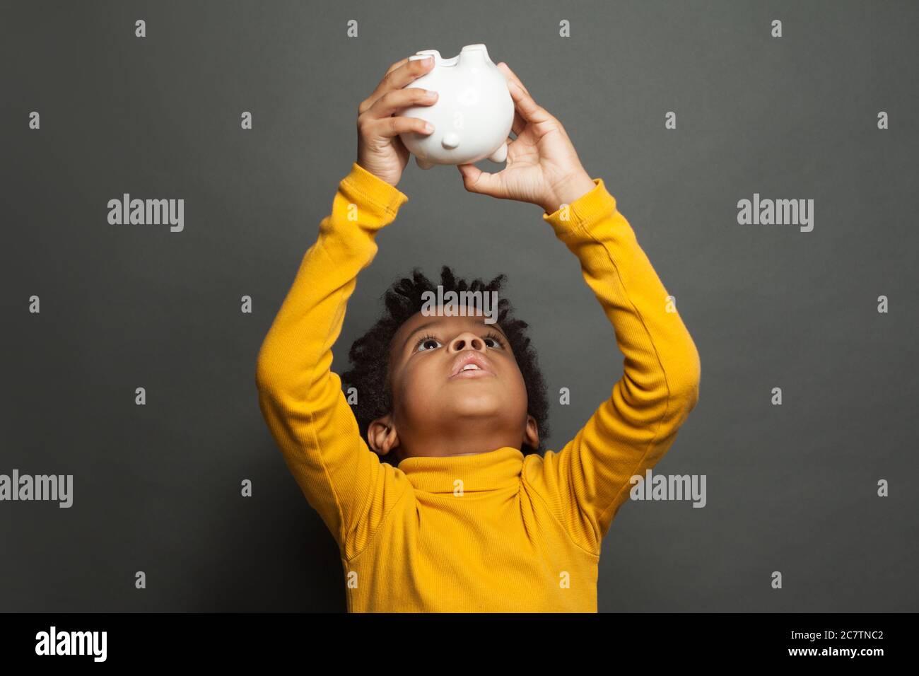 African American kid boy with empty piggy bank Stock Photo - Alamy