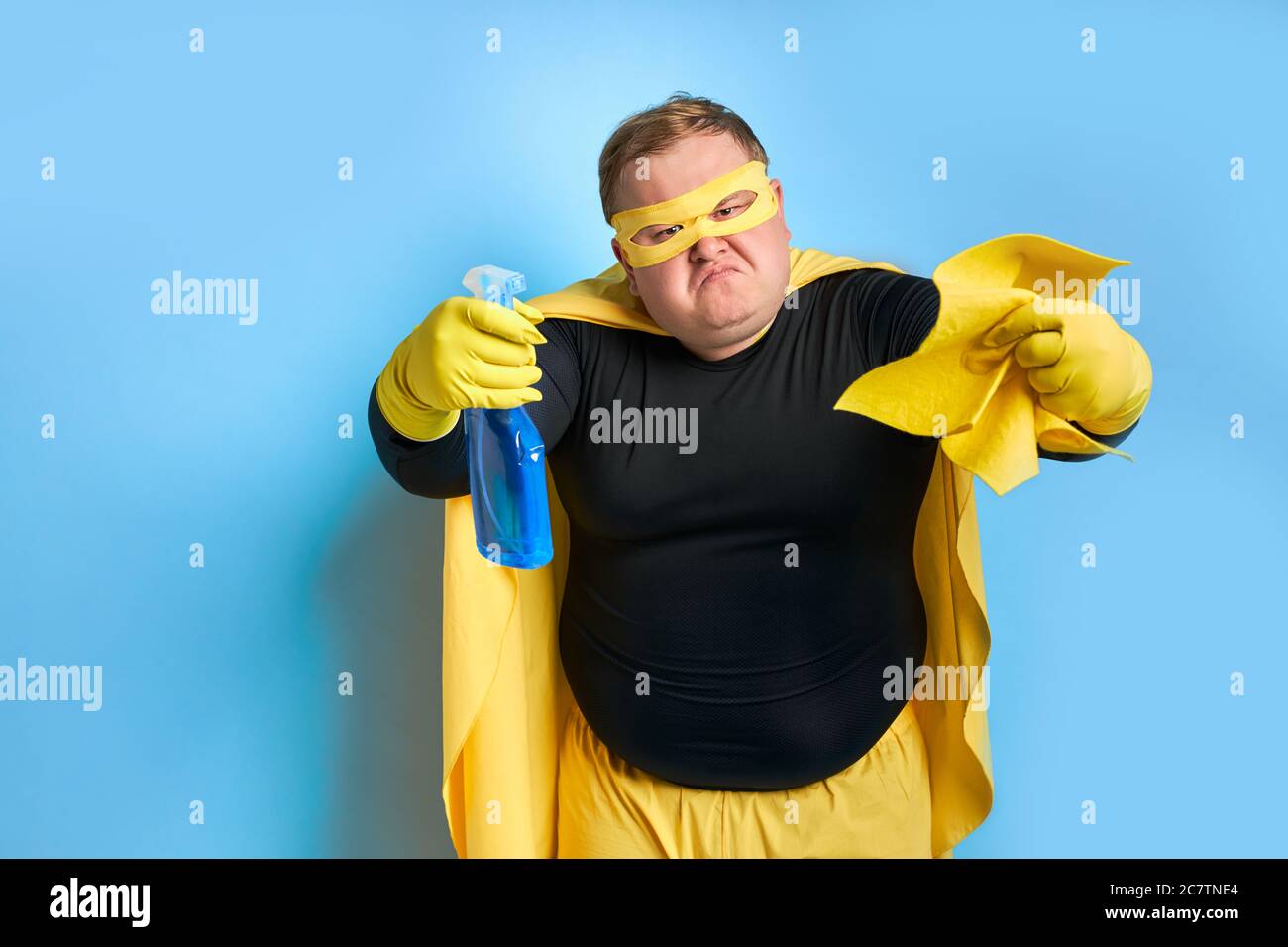 portrait of obese caucasian man with detergents and rag in hands