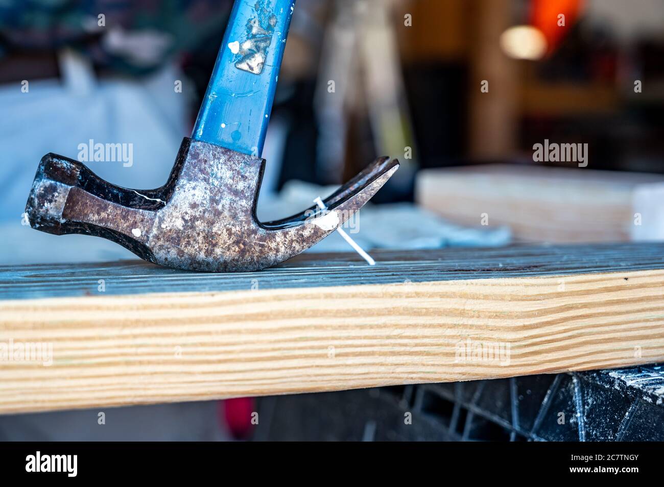 Industrial carpenter tool of a clawed hammer being used as a lever to