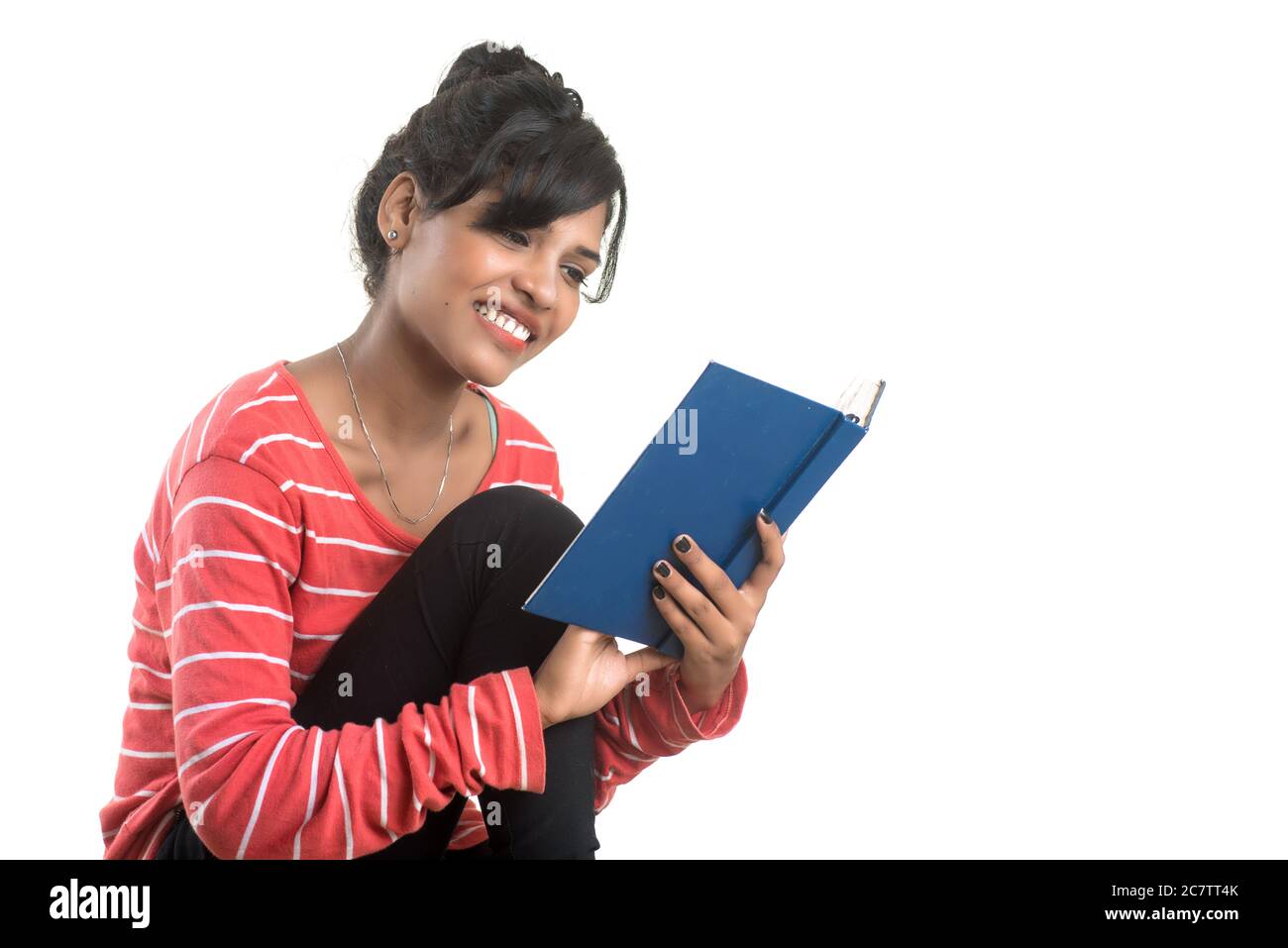 Pretty young girl holding book and posing on white background Stock ...