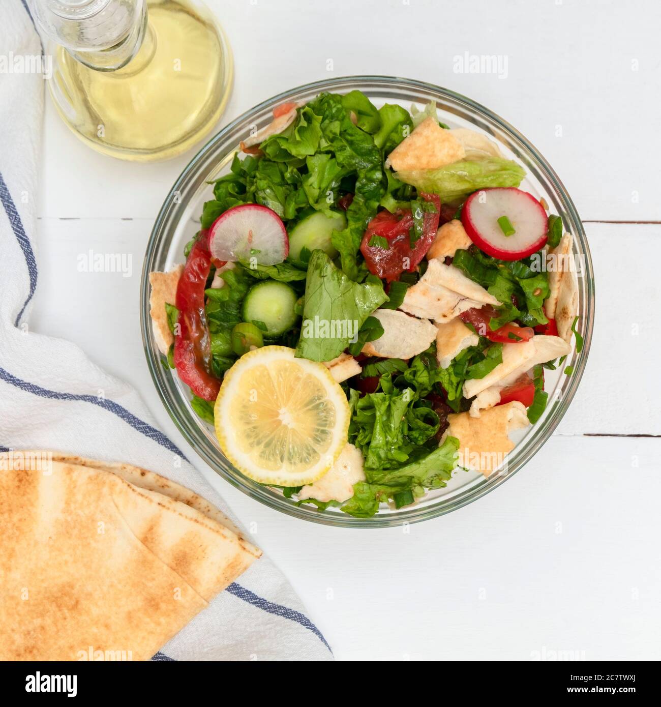 Bowl of Fattoush Lebanese Salad with pita bread on white wooden table Stock Photo