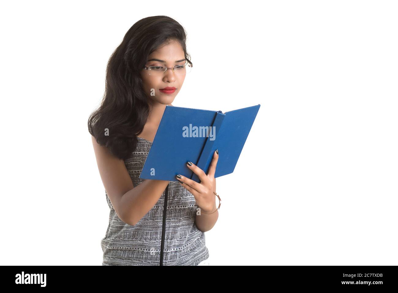 Pretty young girl holding book and posing on white background Stock ...