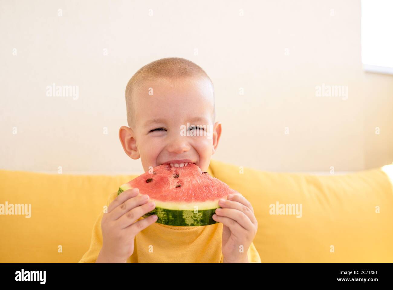 Caucasian young boy eating watermelon and smiling Stock Photo