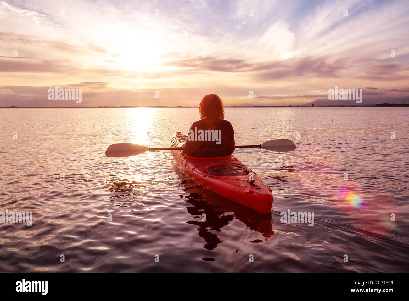 Sea Kayaking in calm waters during a colorful and vibrant sunset Stock ...