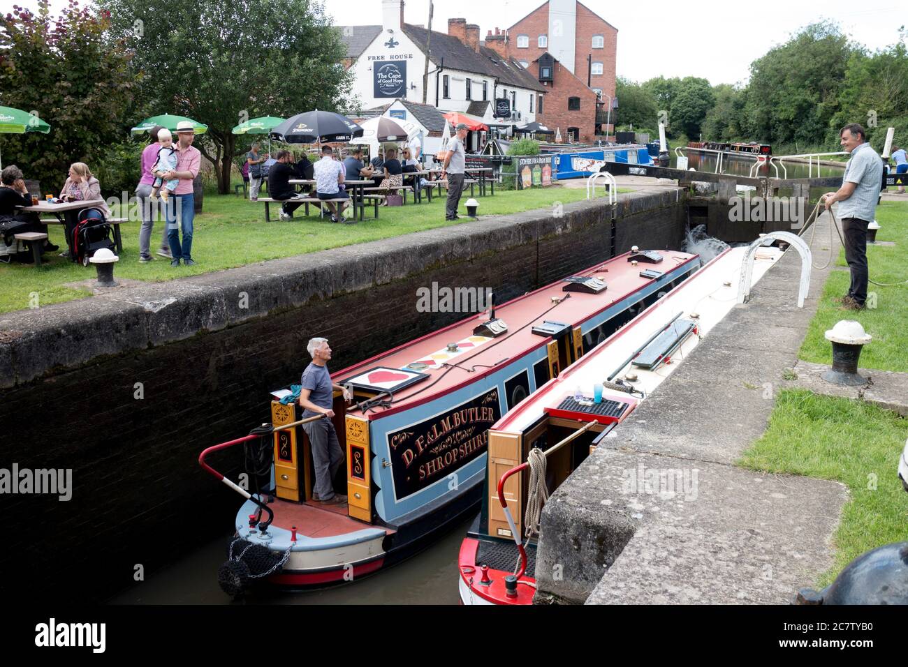 Narrowboats at Warwick Top Lock with people outside The Cape of Good Hope Pub during the easing of Covid-19 lockdown, Warwick, UK. 19th July 2020. Stock Photo