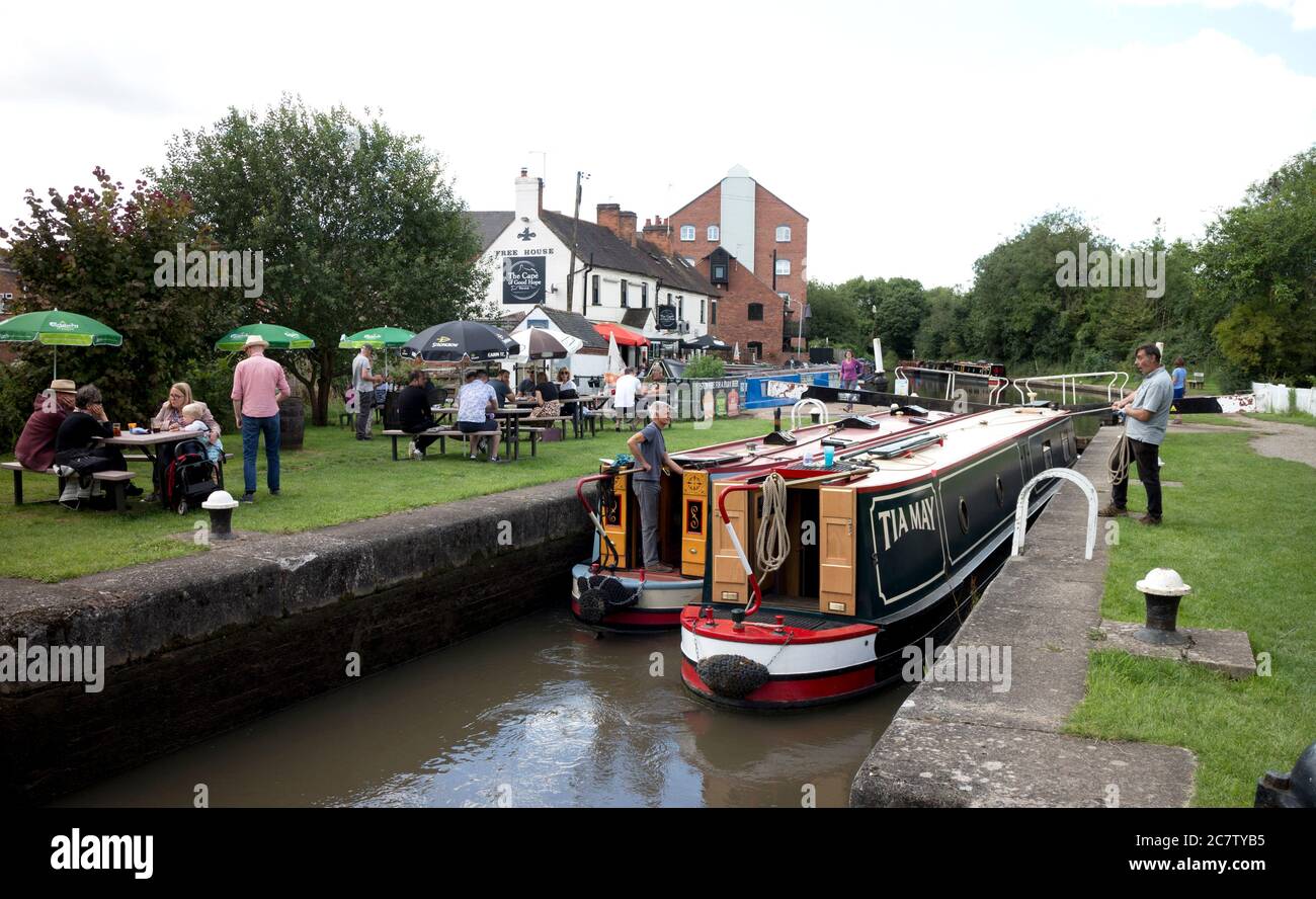 Narrowboats at Warwick Top Lock with people outside The Cape of Good Hope Pub during the easing of Covid-19 lockdown, Warwick, UK. 19th July 2020. Stock Photo