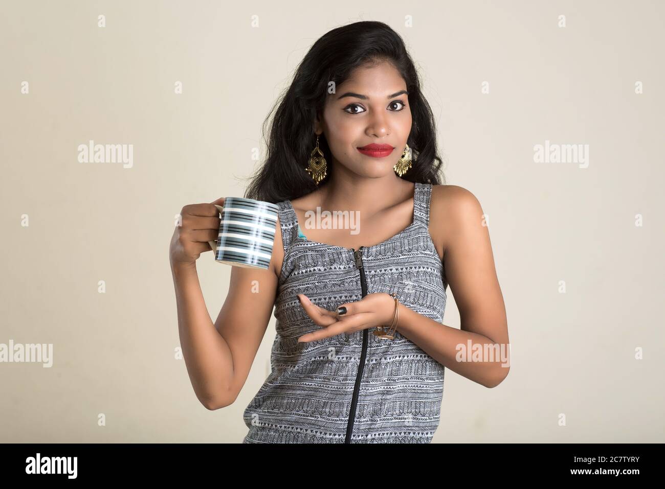 Beautiful young girl with cup of tea or coffee posing Stock Photo - Alamy