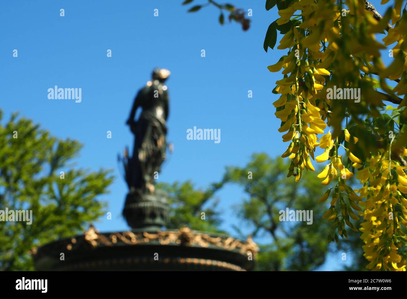 Woman statue and a golden chain tree in the park in Halifax, Canada