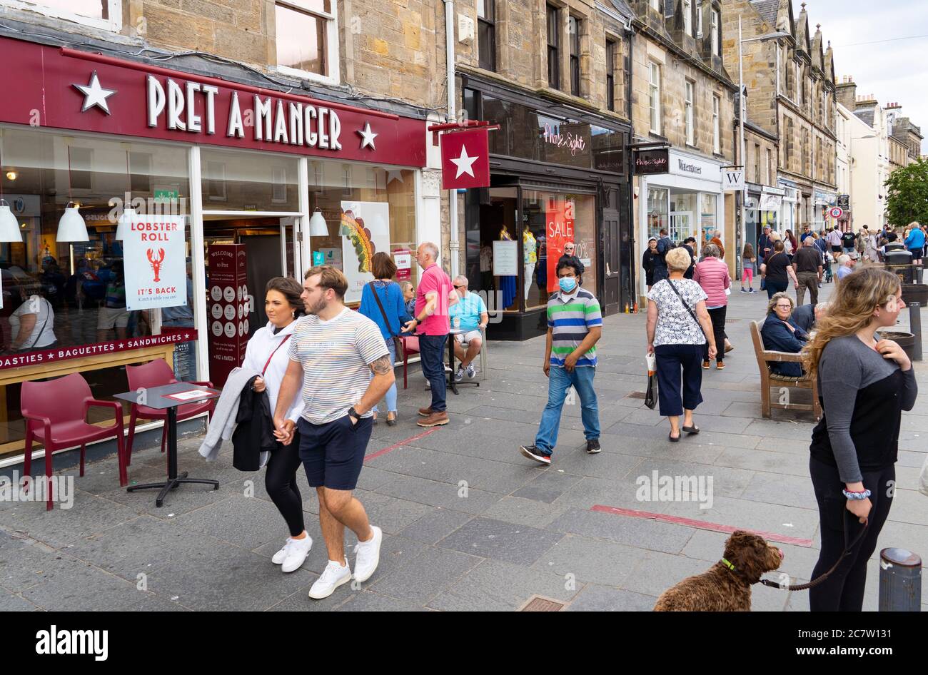 View of people and shops along busy Market Street in central St Andrews , Scotland, UK Stock Photo