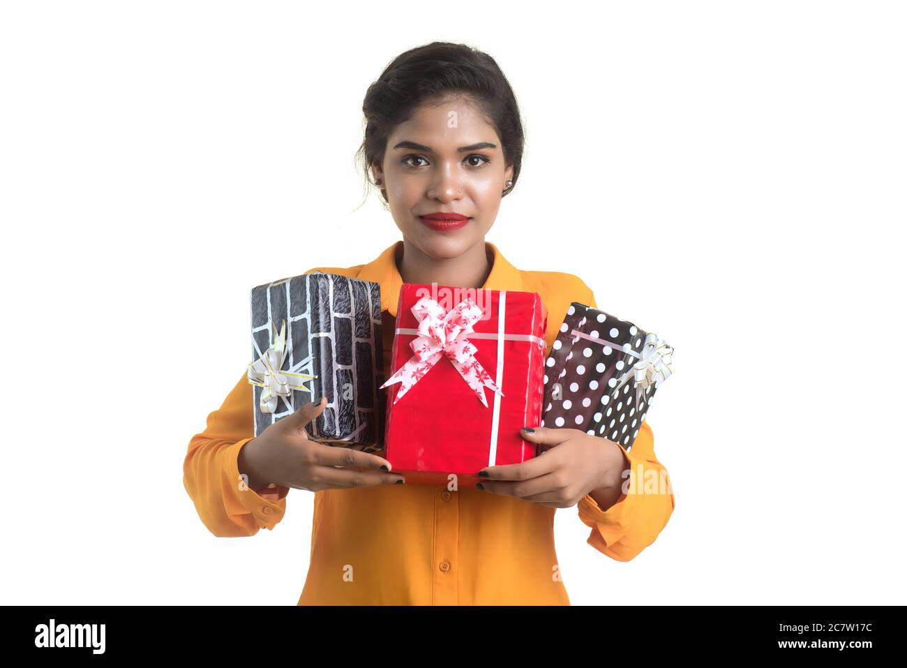 Portrait of young happy smiling Indian Girl holding gift boxes on a ...