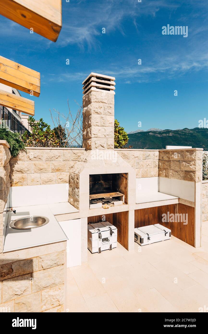 Grill area in the villa by the sea. A large courtyard with a stone grill and an open white stone