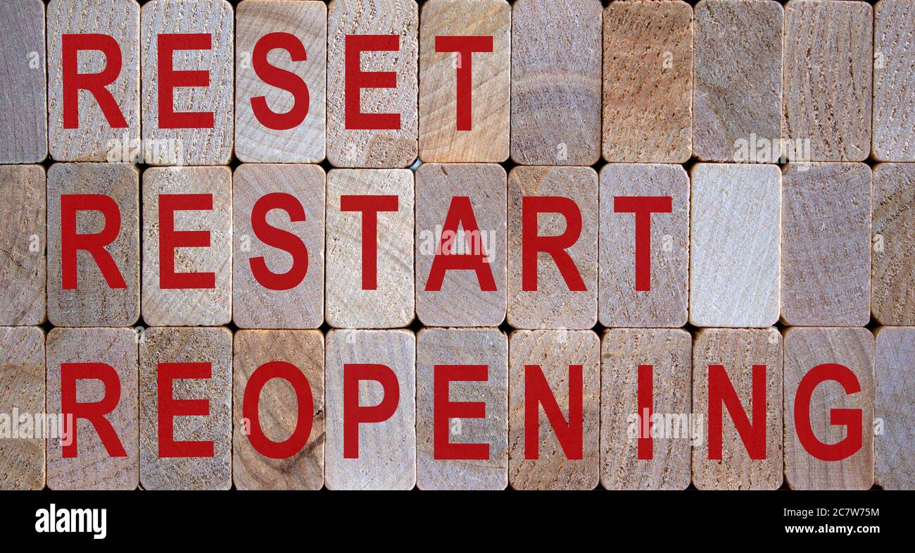 Wooden blocks form the words 'reset restart reopening'. Beautiful wooden background. Stock Photo