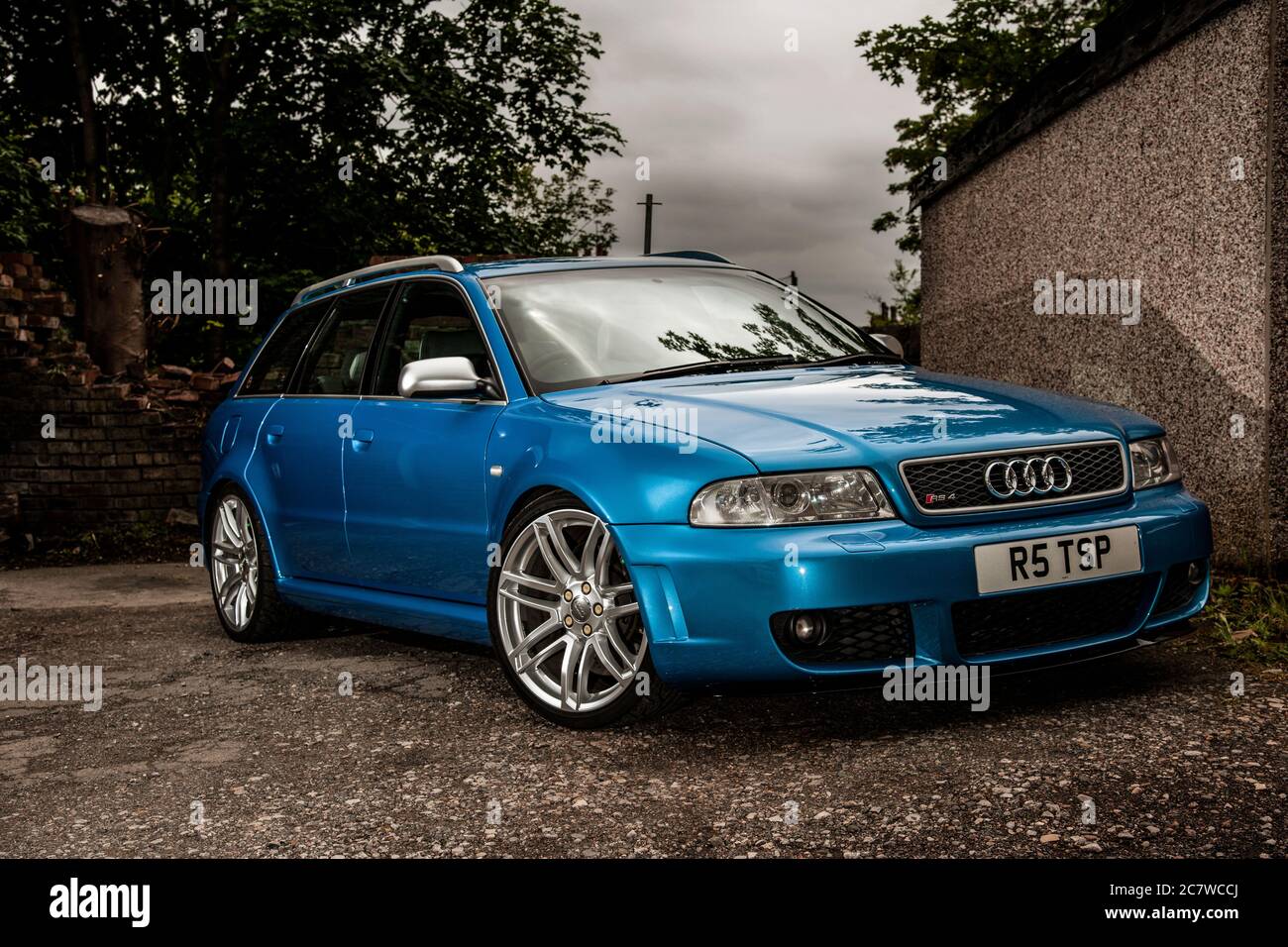 Audi RS6 Avant parked on rough ground beside a garage Stock Photo