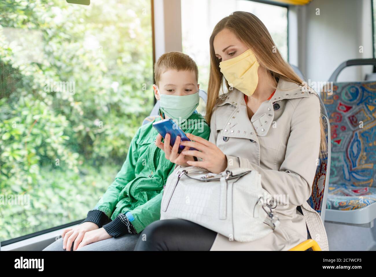 Woman with her son in the bus during coronavirus crisis Stock Photo