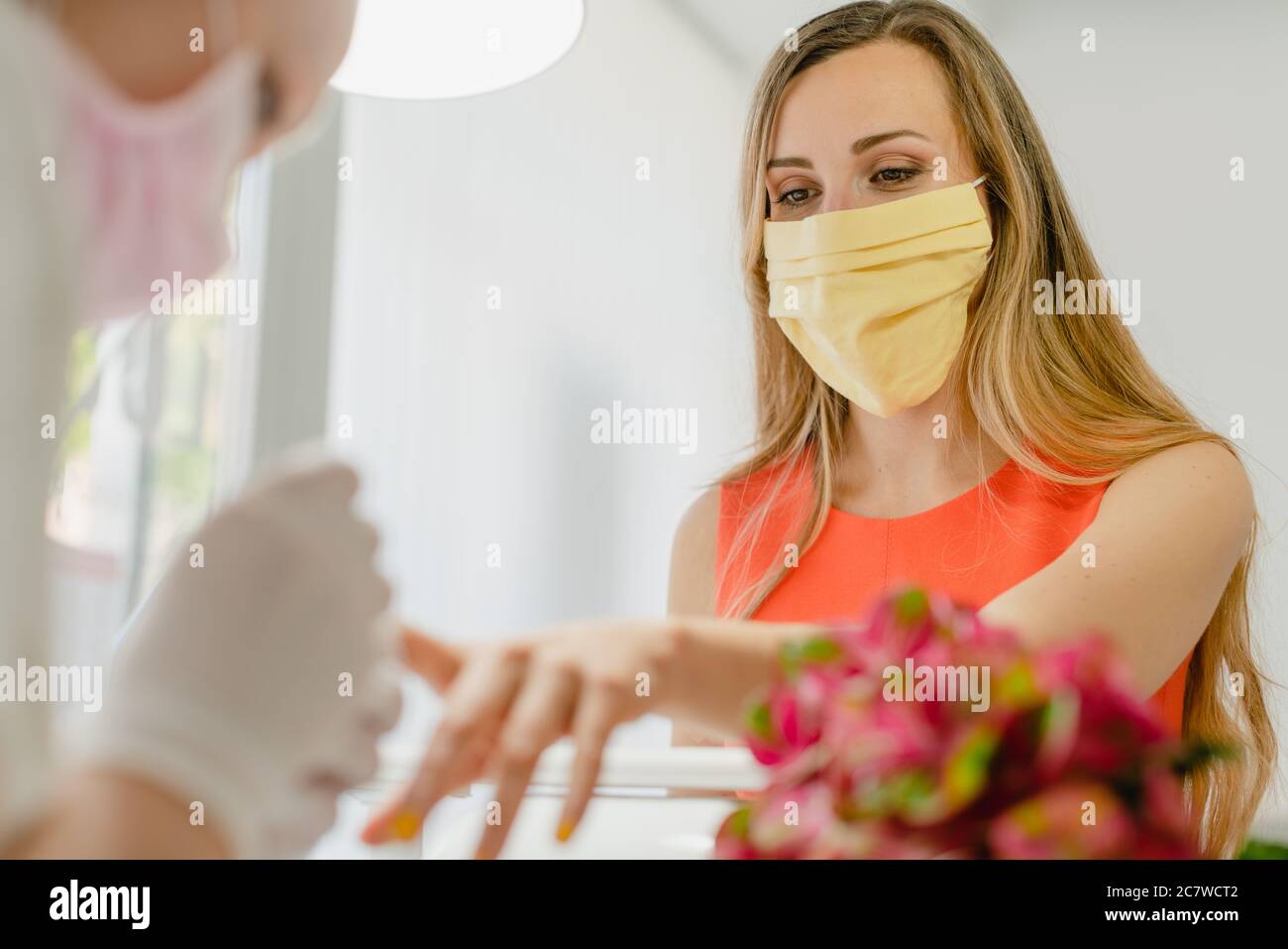 Customer in nail art studio wearing a protective face mask Stock Photo