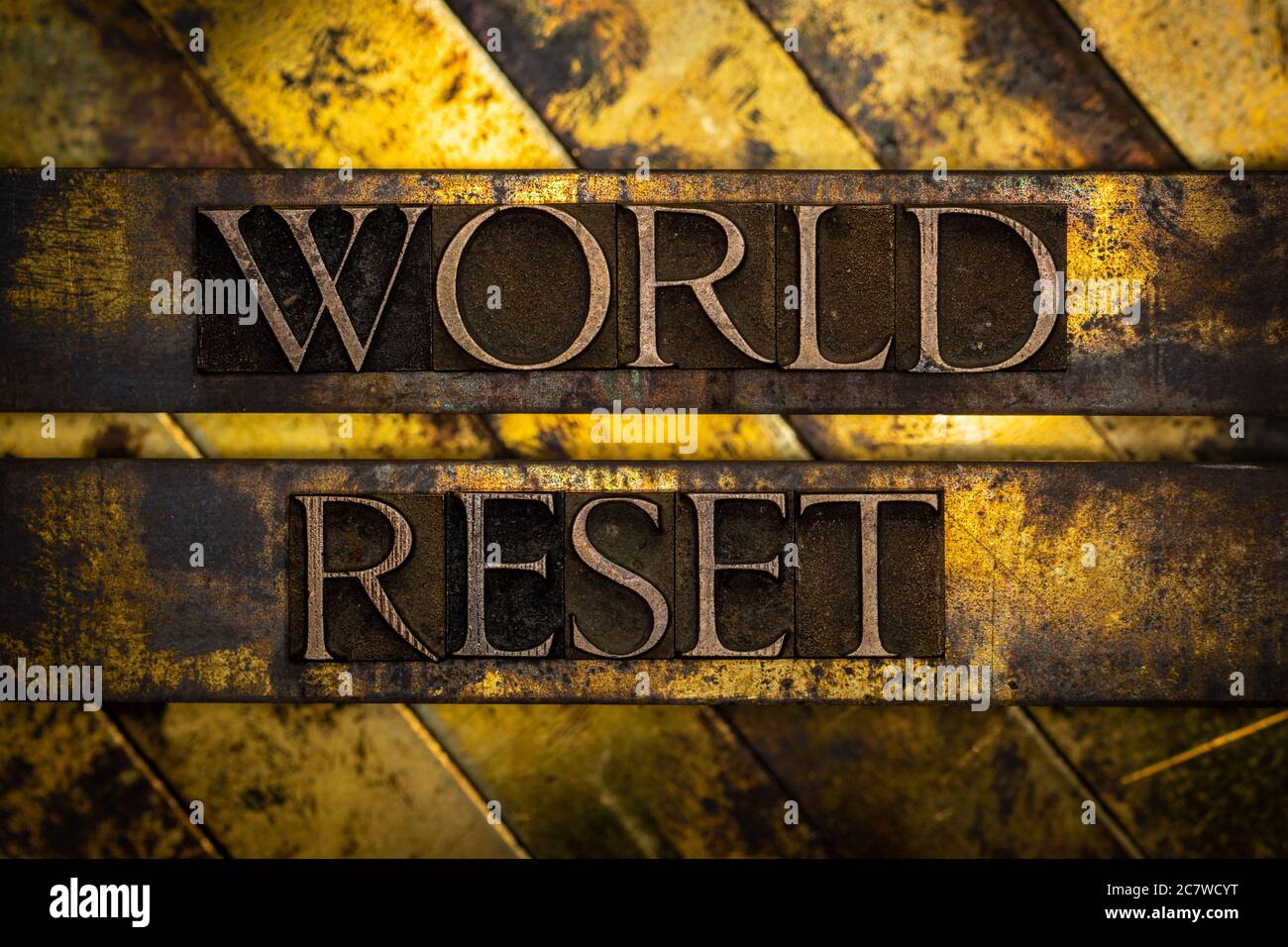 World Reset text formed with real authentic typeset letters on vintage textured silver grunge copper and gold background Stock Photo